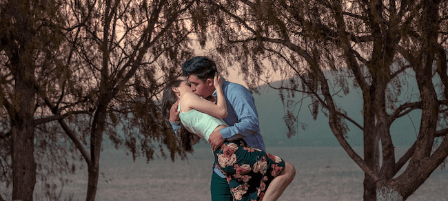 Couple doing a french kiss in the middle of the forest.