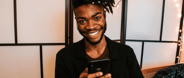 Man smiling at the text message he just received.