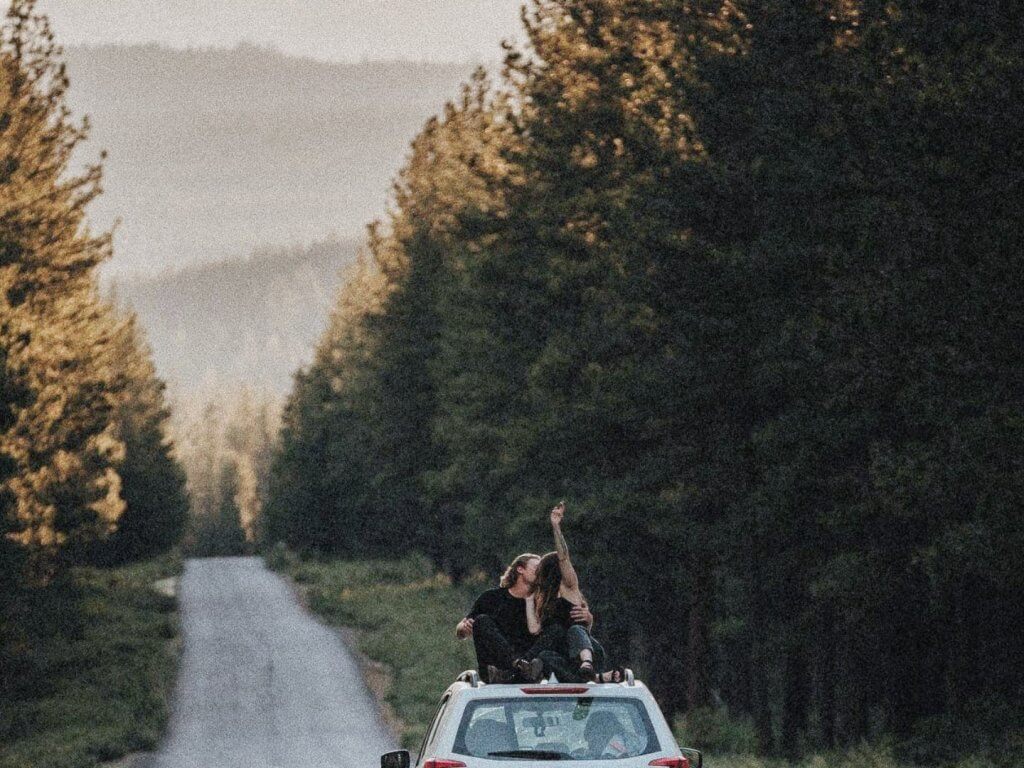 Couple on top of a car.
