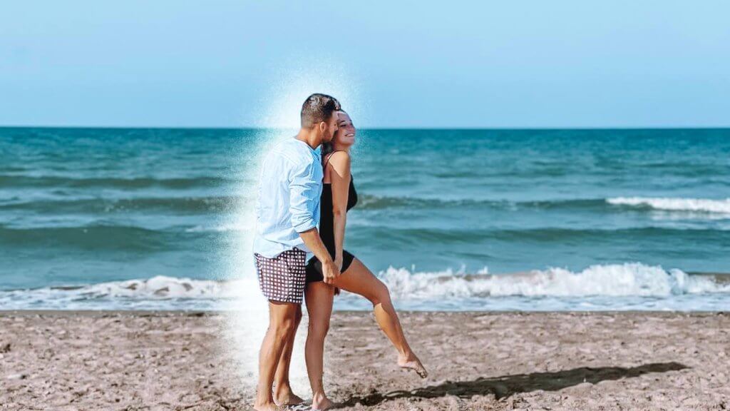 Man surprises woman at the beach.